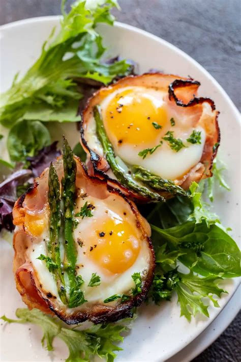 Two Eggs Are On Top Of Asparagus And Lettuce In The Middle