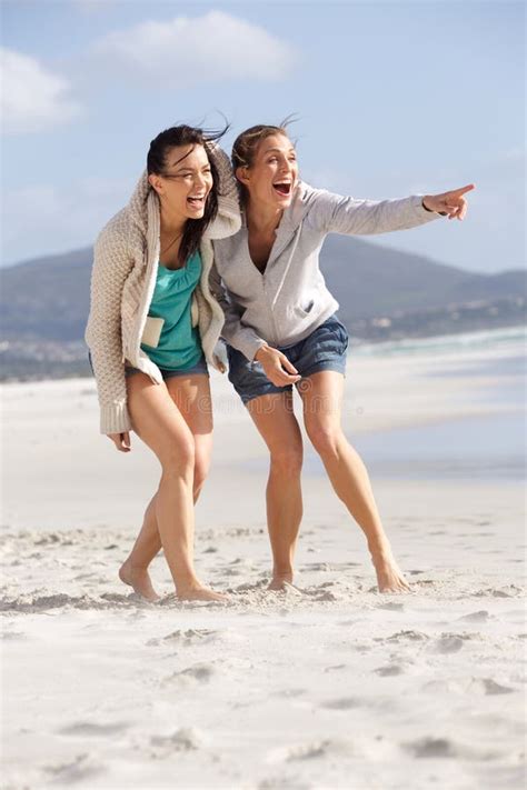 two friends laughing and enjoying life at the beach stock image image of looking brunette
