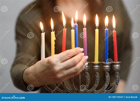 Jewish Woman Lighting Hanukkah Candles In A Menorah Stock Image