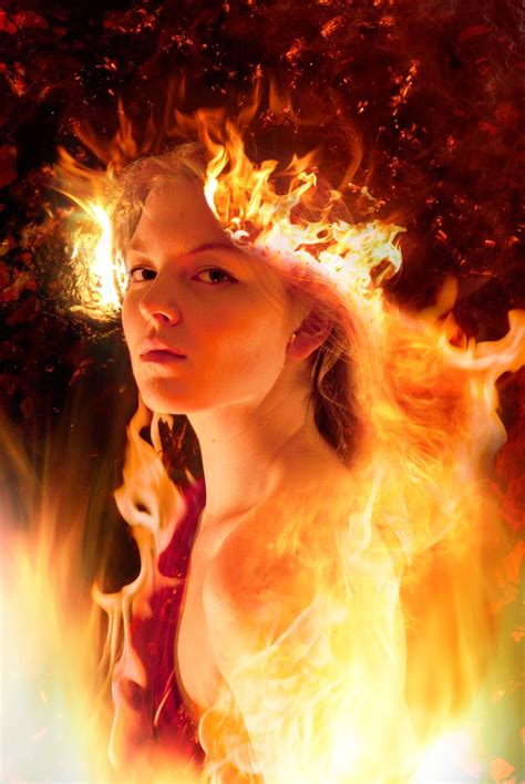 A Woman With Long Hair Standing In Front Of Fire