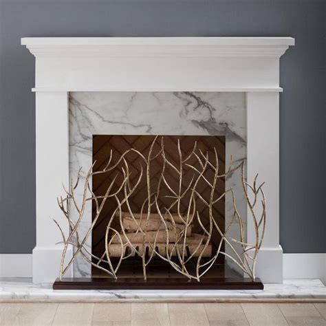 The Fireplace Is Decorated With Branches And Marble