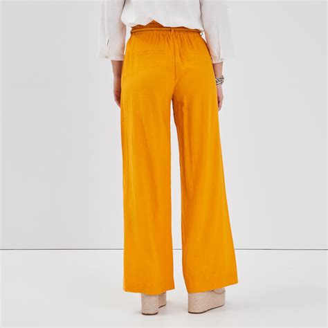 Les pantalons fluides sont confortables et flatteurs pour la silhouette. Pantalon fluide lin jaune or femme | Cache Cache