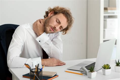 Young Businessman Suffering From Neck Pain In Office Stock Photo