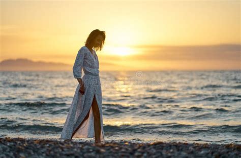Charming Elegant Tourist Woman Strolling Near Seashore On Beach During