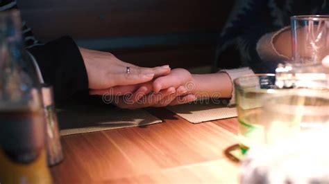 Lesbian Touches The Hand Of Her Partner At A Table In A Restaurant