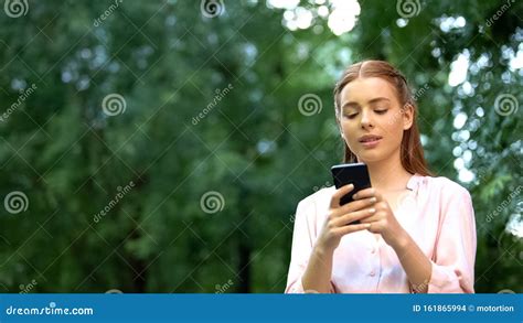 Beautiful Young Girl Chatting On Smartphone Spending Time Outdoor