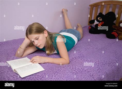 Young Girl Lying On Bed Sur Son Ventre La Lecture Dun Livre Banque D