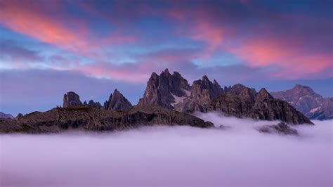 Fog And Sunset Over Dolomite Mountains In Italy