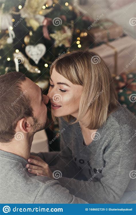Loving Young Couple Spends Christmas At Home Near A Decorated Festive