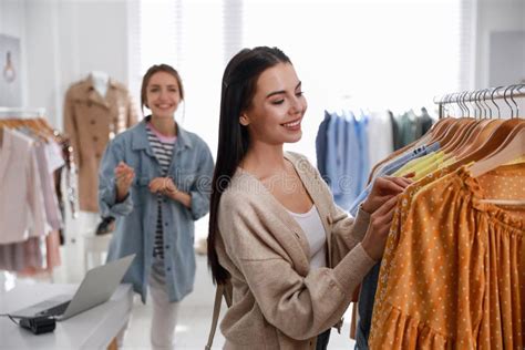 Shop Assistant Helping Customer To Choose Clothes In Modern Boutique Stock Image Image Of