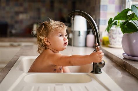 Premium Photo Baby Taking Bath In Kitchen Sink