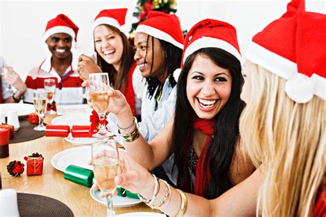 Christmas can mean different things to different people. Laughing Group Of Young People Round Christmas Dinner Table Stock Photo - Download Image Now ...