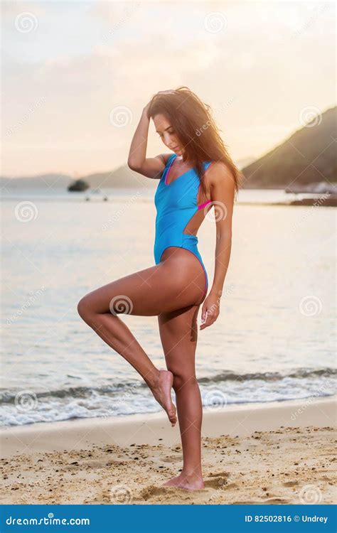 Attractive Tanned Female Tourist In Swimwear Standing On Seashore At