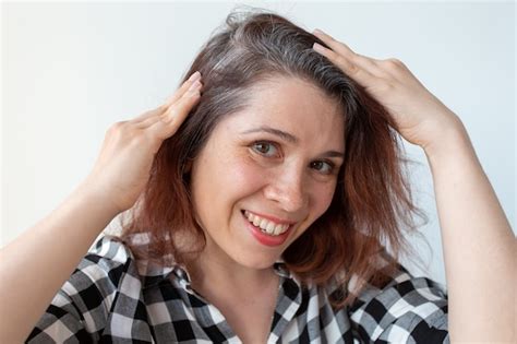 Mujer joven muestra sus raíces de cabello gris concepto de