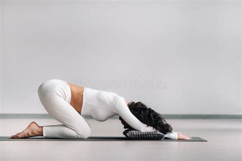 A Woman Doing Yoga On A Mat Kneeling Makes A Bow Stretching Her Arms