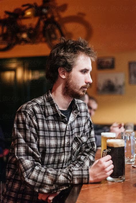 Young Man Drinking Beer At Bar By Stocksy Contributor Boris