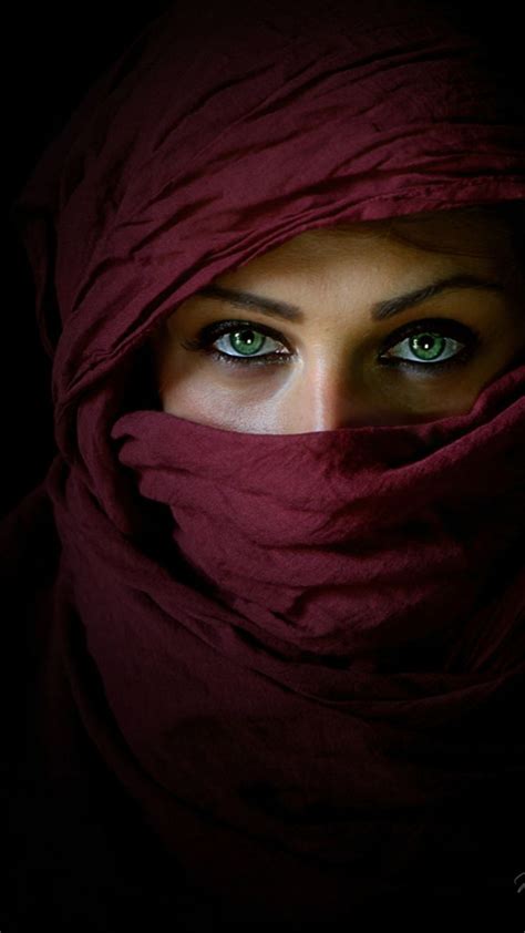 a woman with green eyes wearing a red scarf