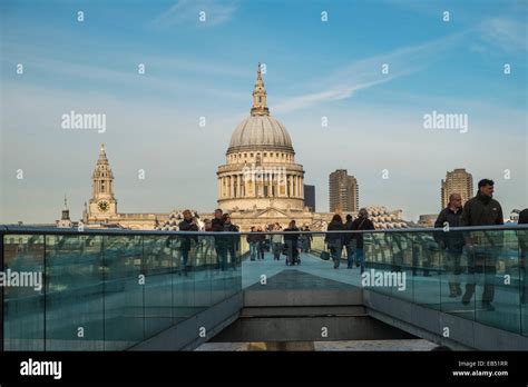 People Walking Across Millenium Bridge With View Of St Pauls Cathedral