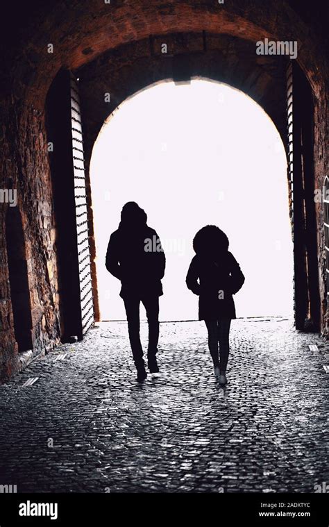 Young Man And Woman Walking Through A Tunnel Passage Stock Photo Alamy