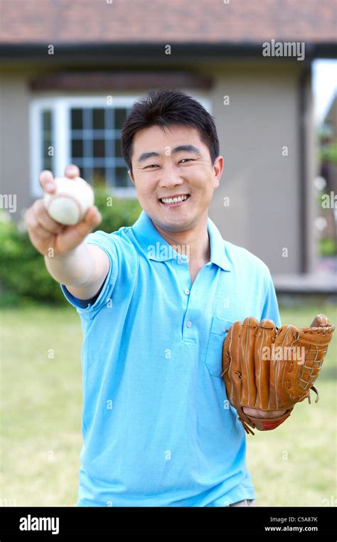 Portrait Of Mid Adult Man Holding Ball And Baseball Glove Stock Photo