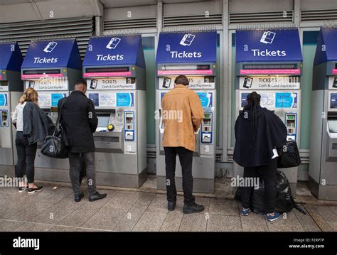 Rail Passengers Use Self Service Ticket Machines At London Bridge Train