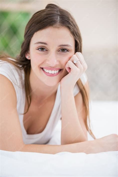 Premium Photo Portrait Of Smiling Woman Lying On Bed