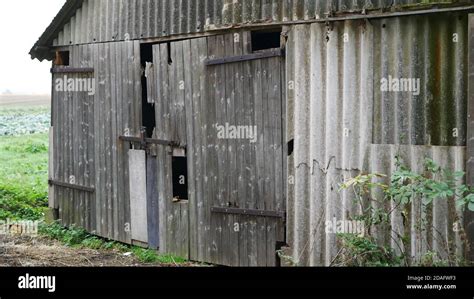 Old Rotten Eerie Barn In The Fields With Closed Gate Stock Photo Alamy
