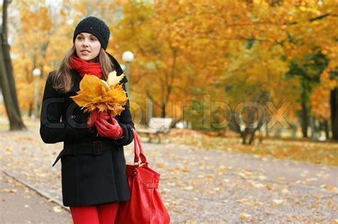 Update your wardrobe today with free delivery options available. A happy woman in autumn clothes on a beautiful park ...