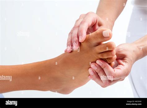 Extreme Close Up Therapist Doing Reflexology Massage On Human Female Foot Isolated On White