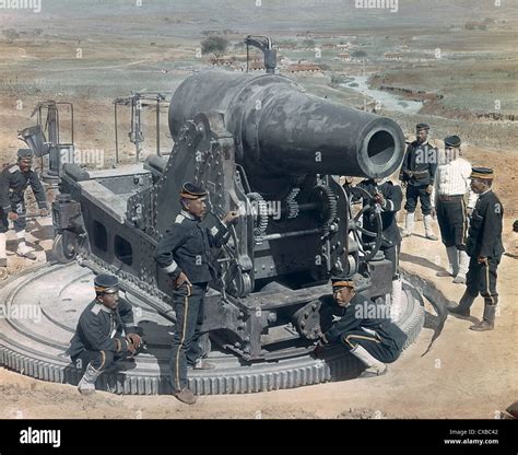 Foto coloreada de soldados japoneses reunidos alrededor de un cañón de cm conocido como un