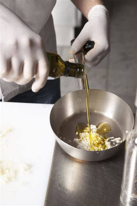 The Cook Pours Olive Oil Into A Frying Pan For Cooking Stock Image