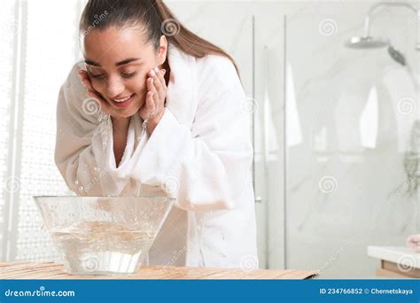 Beautiful Young Woman Washing Her Face With Water In Bathroom Space