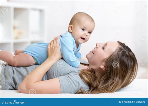 Happy Mother And Baby Hug And Play Lying Indoors Stock Image Image Of