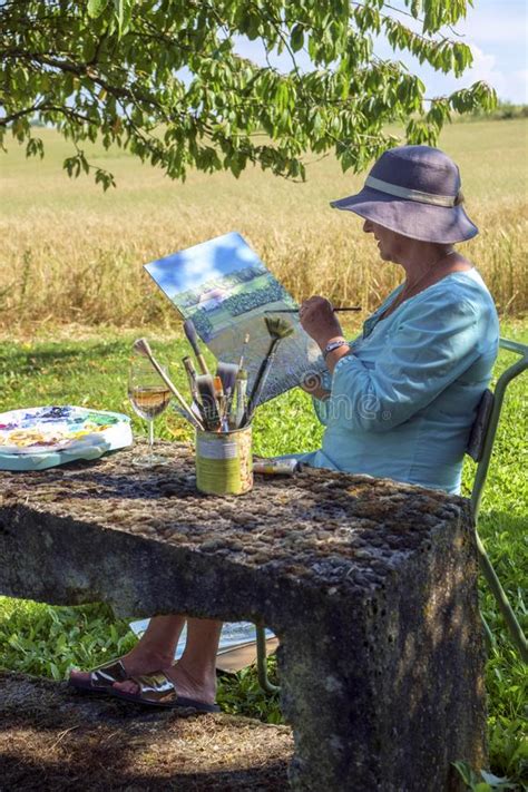A Lady Artist Sits In Shade Working On A Painting Stock Image Image