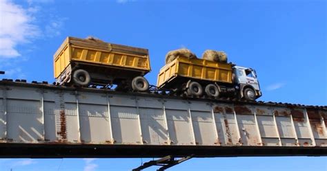 A Truck Driving Across Vitim River Bridge With No Guardrails In Siberia