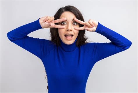 Free Photo Impressed Young Pretty Girl Showing V Sign Symbols Near Eyes
