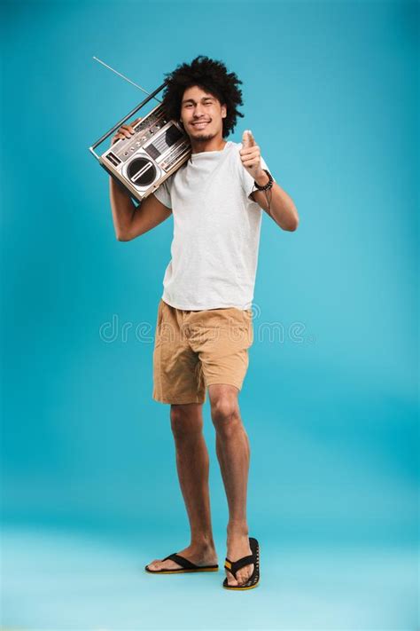 Guy Holding A Boombox On His Shoulder And Lying On A Bench Stock Photo