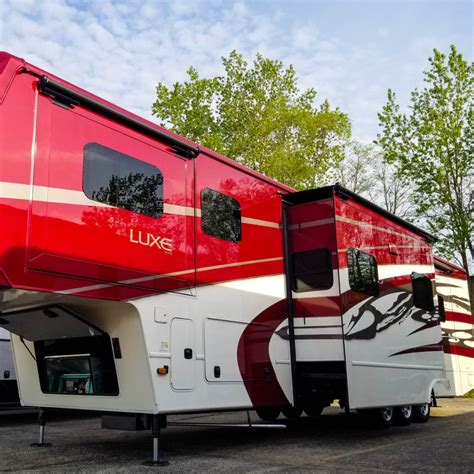 A Red And White Recreational Vehicle Parked In A Parking Lot Next To