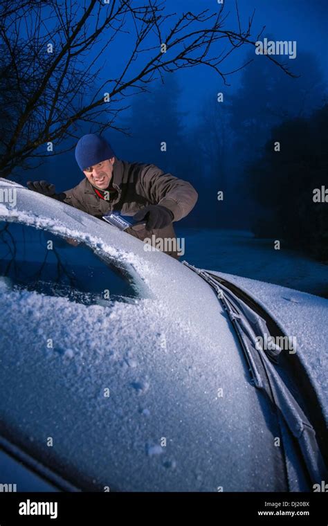 Man Scraping Ice From A Frost Covered Car Windscreen Stock Photo Alamy
