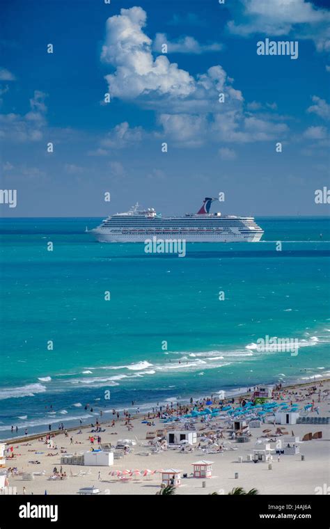 Cruise Ship Going Out To Sea With A Crowded Beach In The Foreground