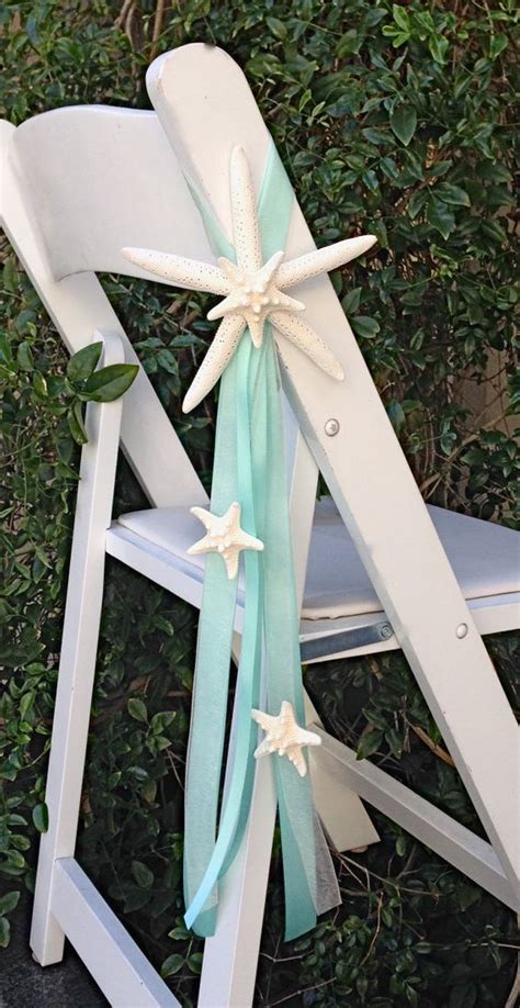 A White Chair With Starfish On The Back And Ribbon Tied To Its Seat