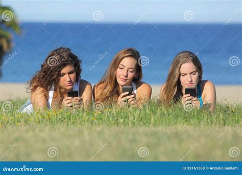 groupe de trois filles d adolescent dactylographiant au téléphone portable se trouvant sur l
