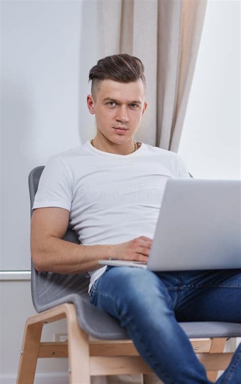 Handsome Young Man Sitting And Working On Laptop Computer Stock Image
