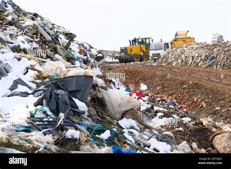 Dump Truck Unloading Garbage Over Vast Landfill Environmental