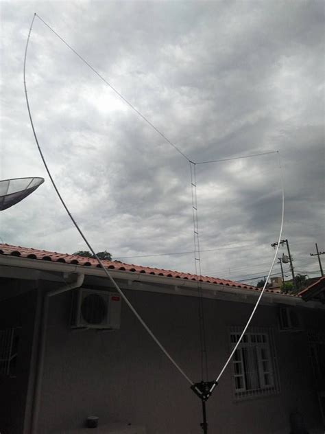 an antenna on top of a house with cloudy skies in the backgrouund