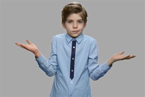 Boy Shrugging Shoulders Against Gray Background Stock Photo Image Of