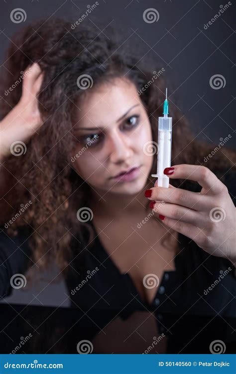 Young Woman With Drug Addiction On Dark Backgroundsyringe In Focus