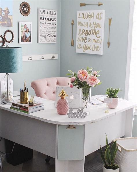 A White Desk Topped With Lots Of Pink Flowers Next To A Lamp And
