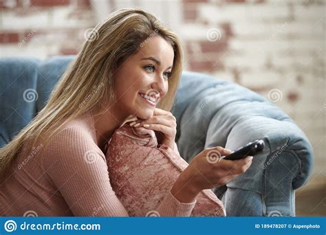 Gorgeous Blonde Woman Relaxes On Couch In Living Room Stock Image