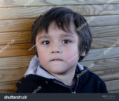 Portrait Adorable Boy Standing Next Wooden Stock Photo 1196965156